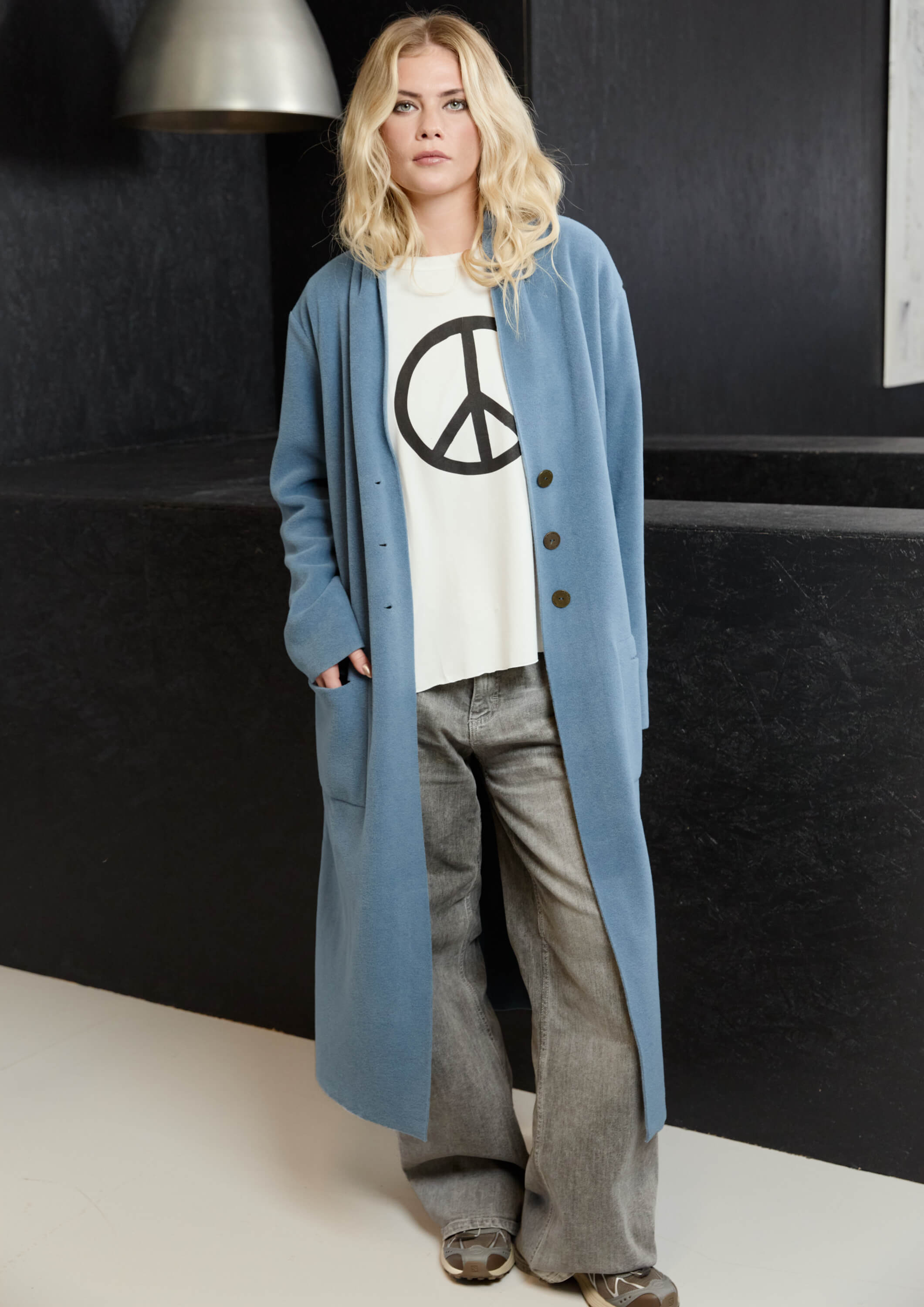 Person wearing a long blue coat.