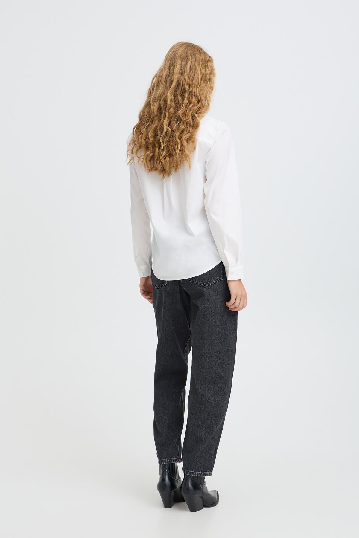 Back view of a model wearing b.young Kizion black denim barrel-leg jeans