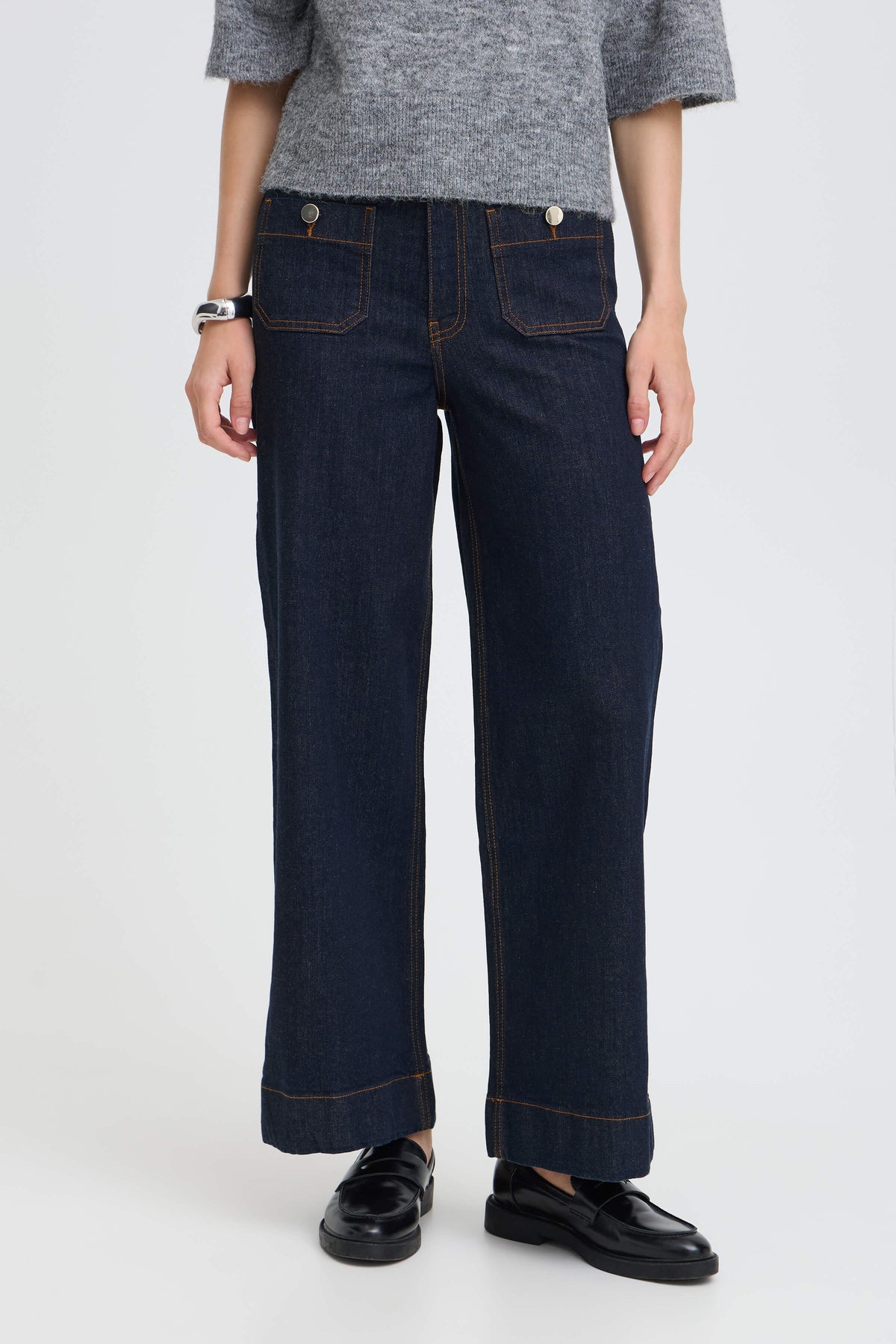 Close-up of a model wearing b.young Komma dark blue wide-leg jeans with high waist and hip button details