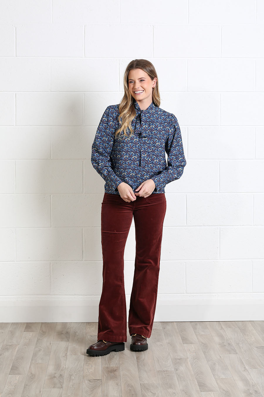 Model wearing the Rant & Rave Isabella tie-neck blouse with trousers