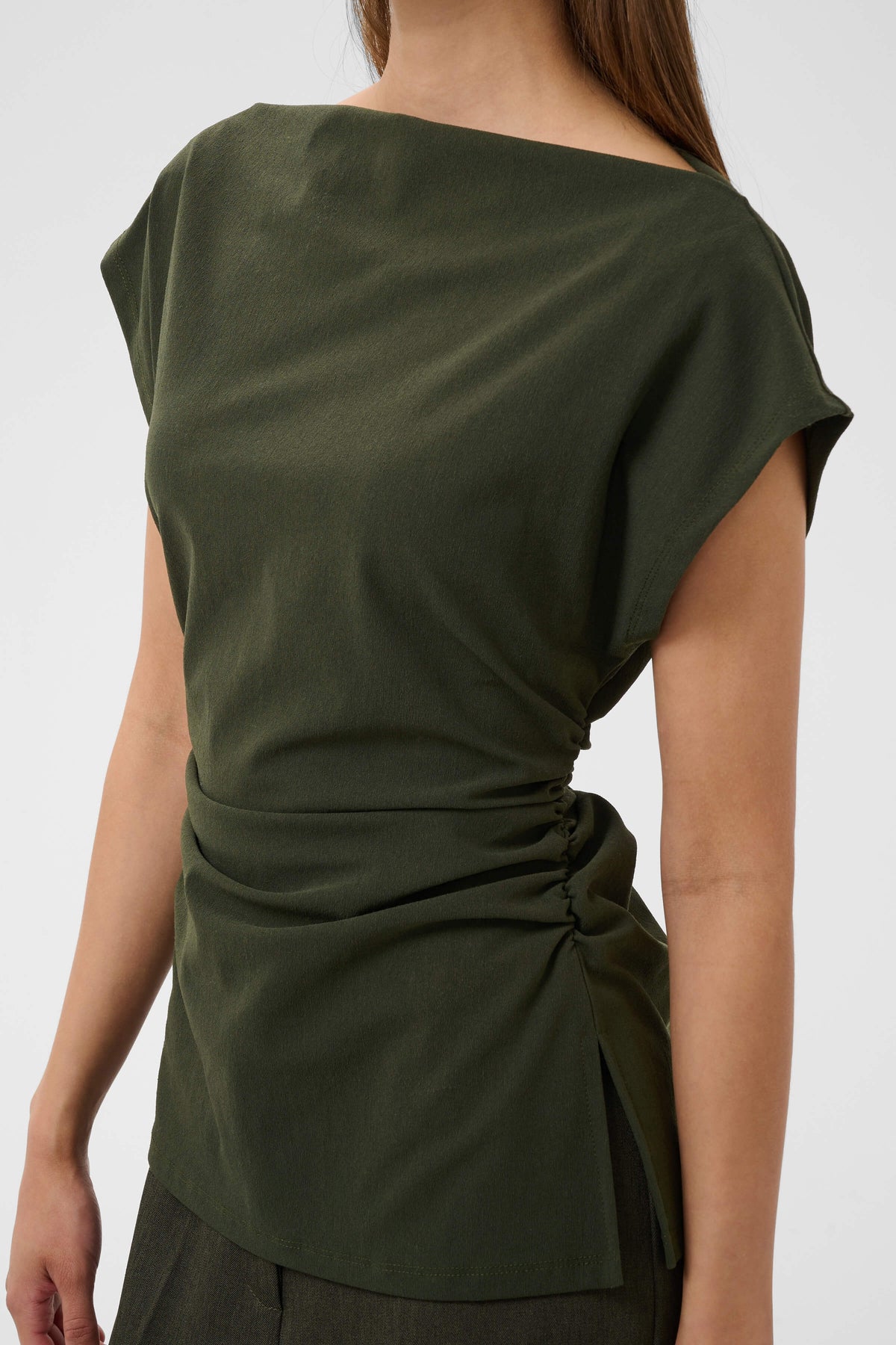 Close-up of the Eirlys Top with side ruching and a subtle slit