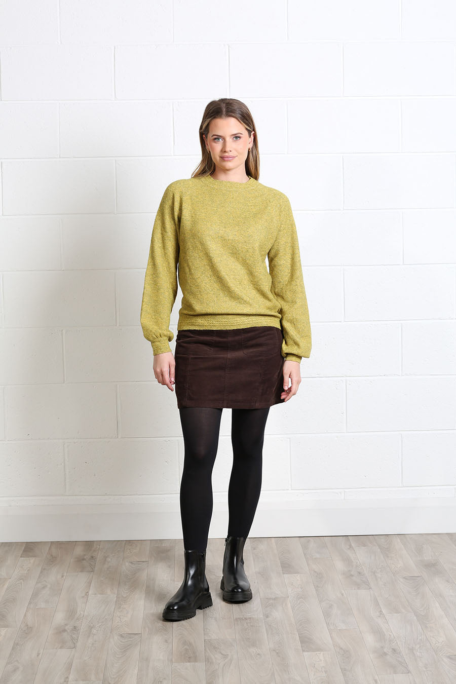 Women’s corduroy mini skirt styled with knitwear and ankle boots