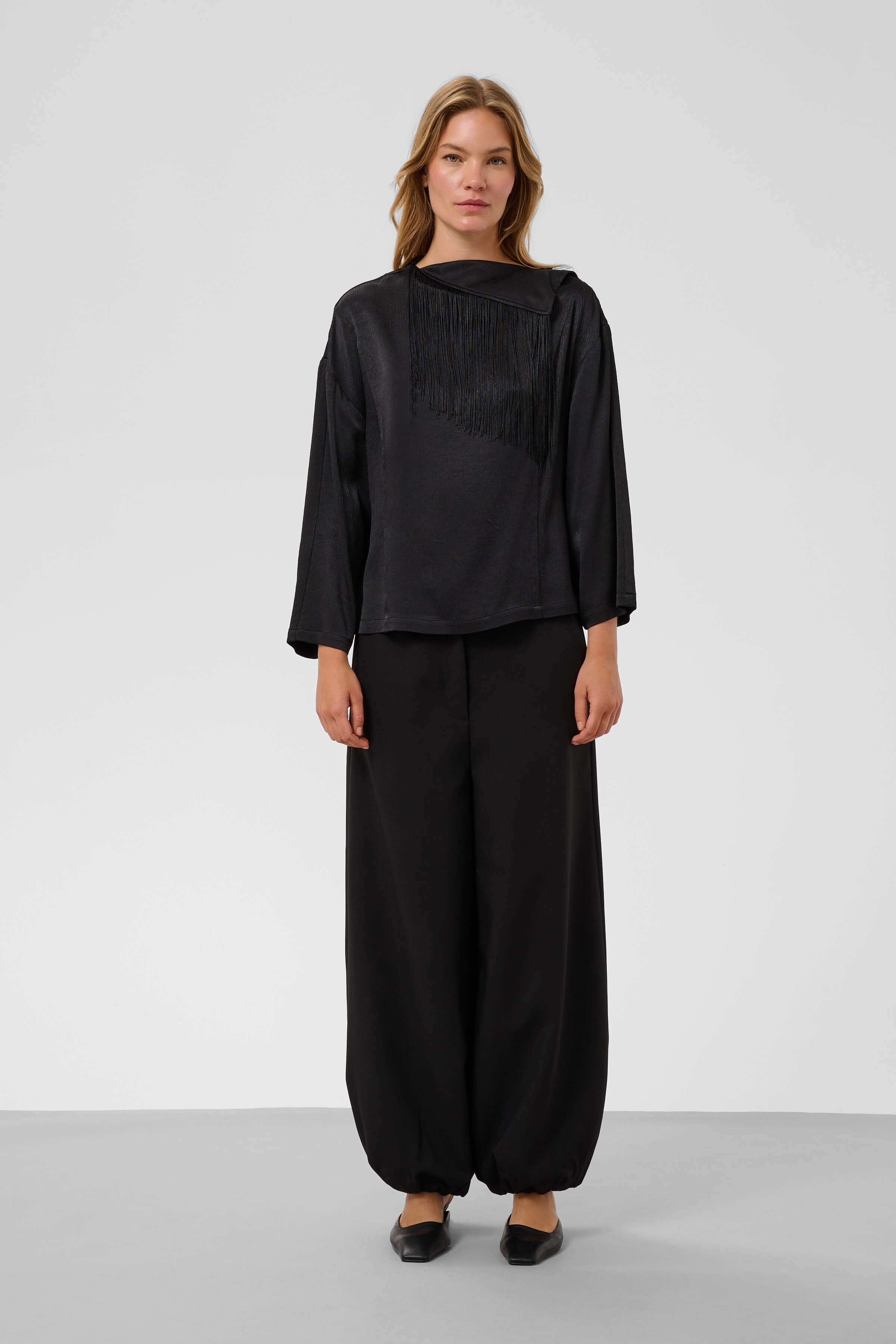 Model wearing the Soaked in Luxury Mirabella asymmetric blouse