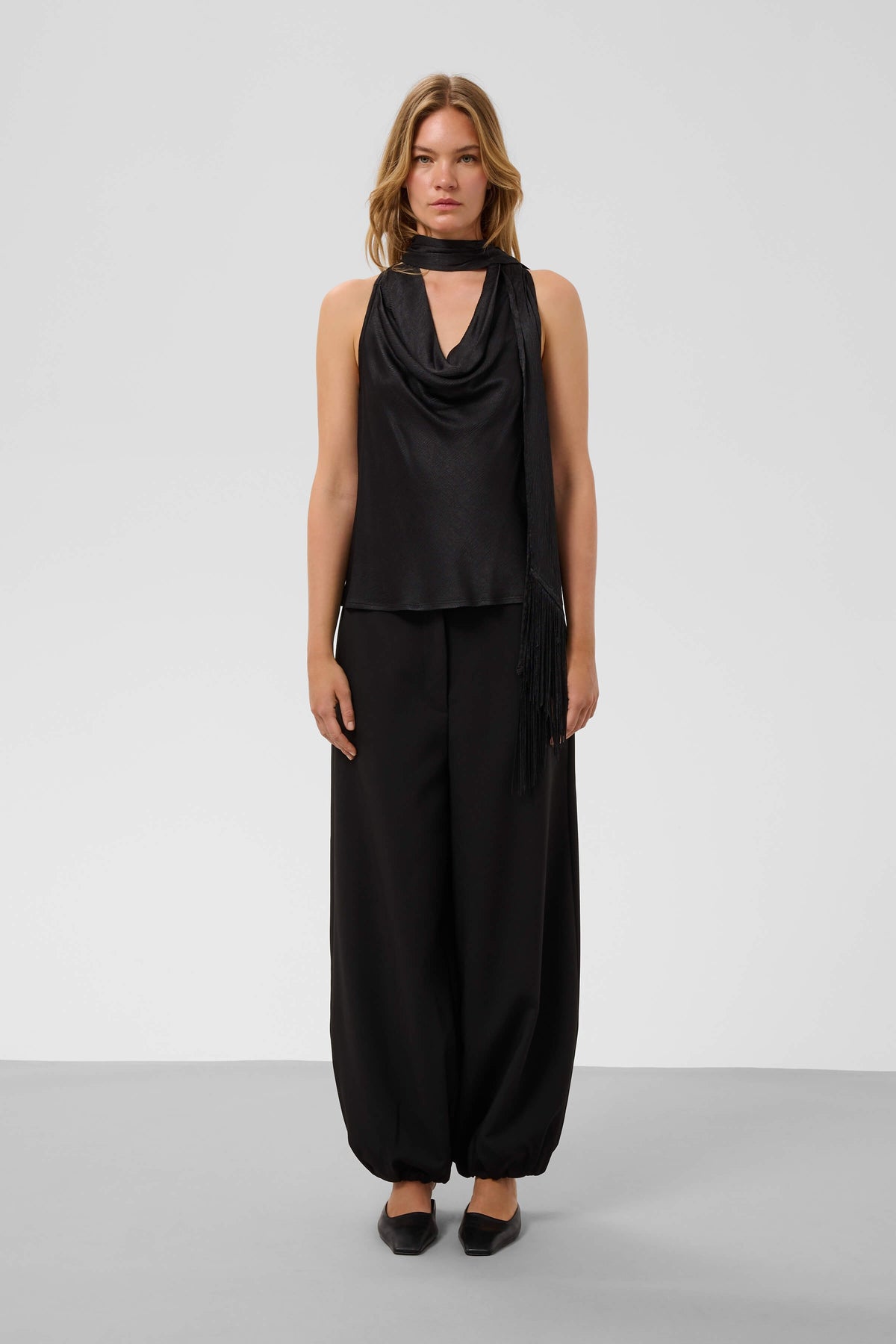 Model styling the Soaked in Luxury Mirabella Aragat scarf top with trousers