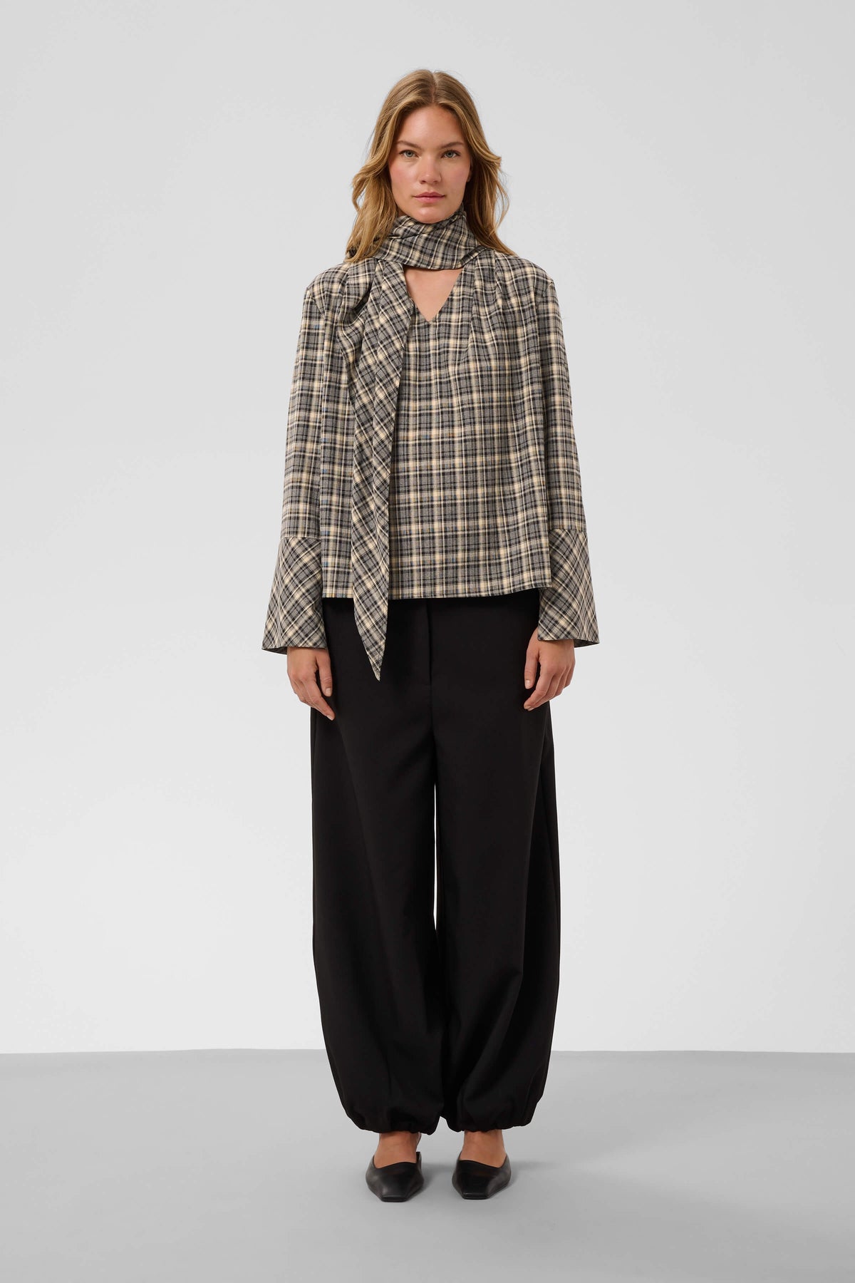 Front view of the Shiba Blouse featuring a V-neckline and flared cuffs