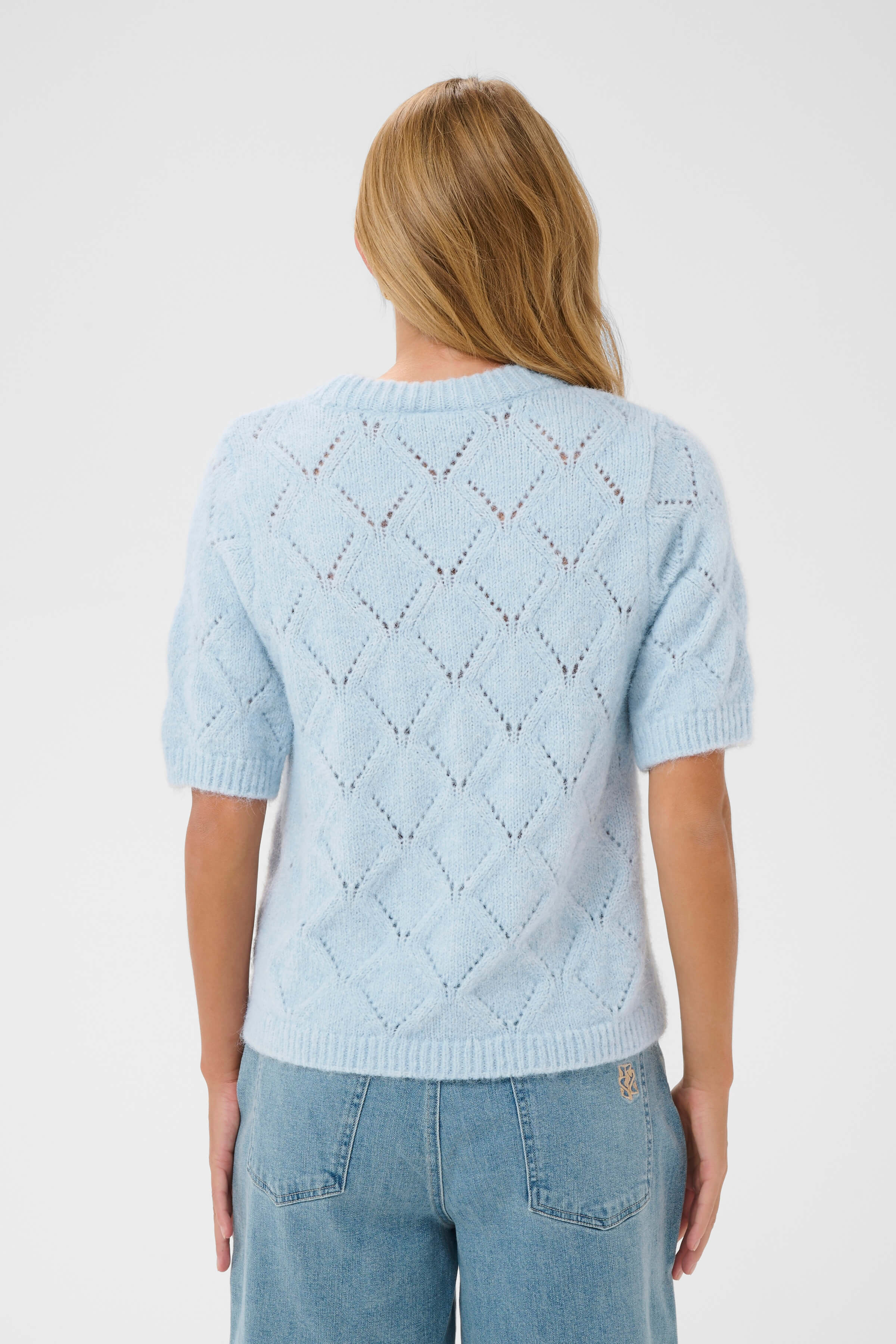 A light blue short-sleeve knit with diamond-shape detailing 