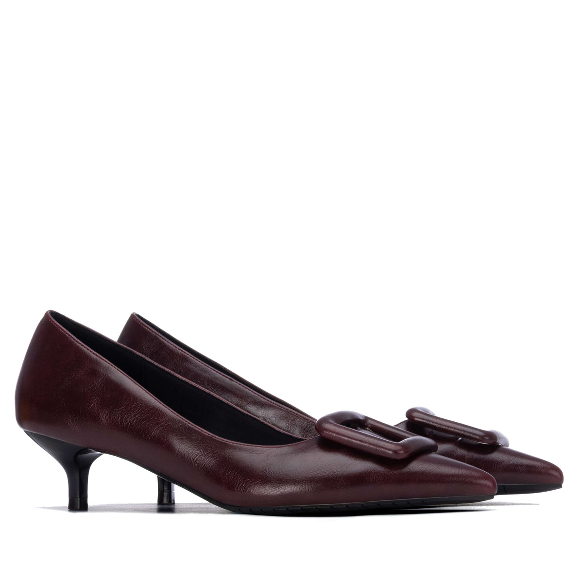 A pair of women's pointed-toe pumps in dark burgundy , featuring a decorative square buckle detail on the vamp and a kitten heel