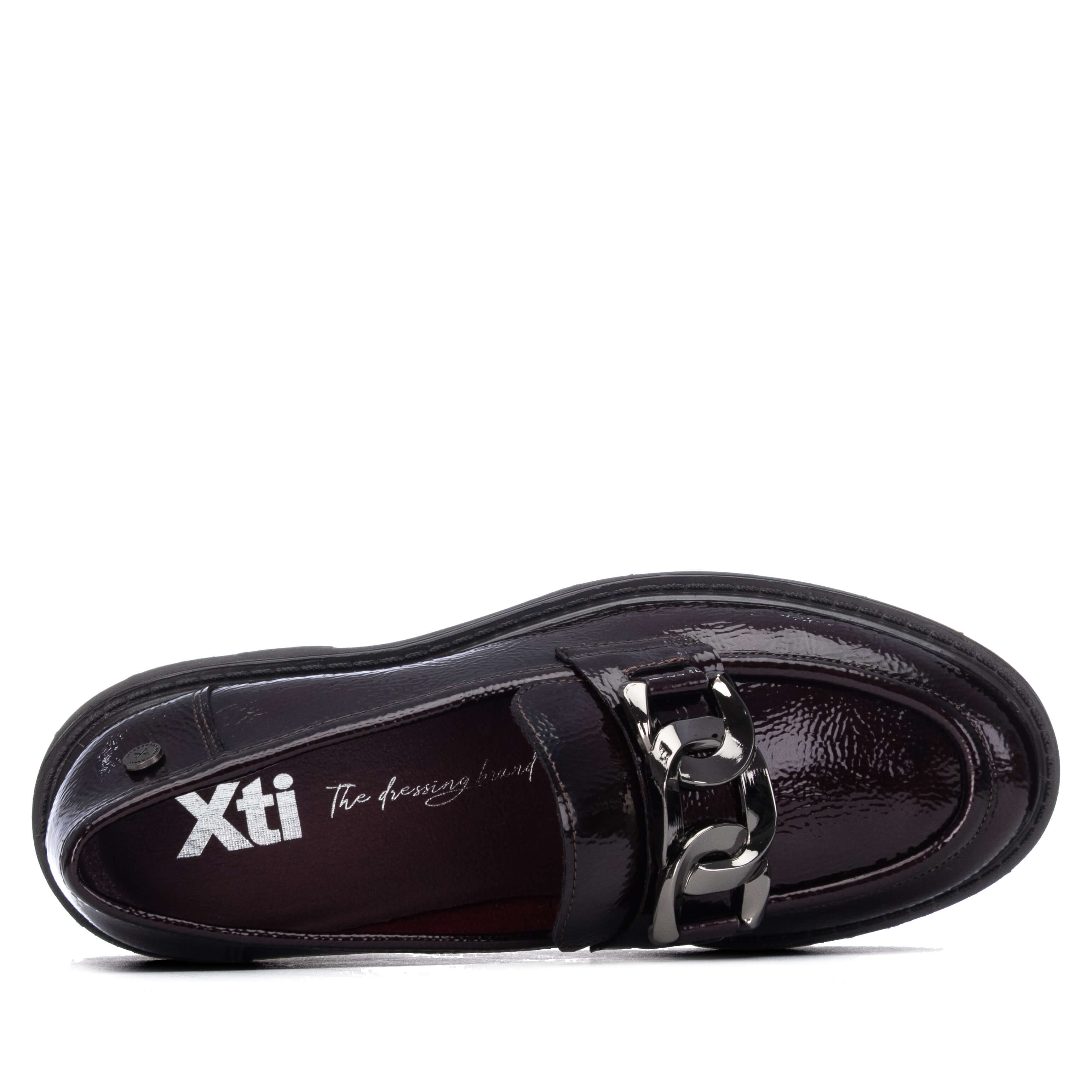 A single black patent leather loafer across the vamp and the brand name 'Xti' printed on the insole.